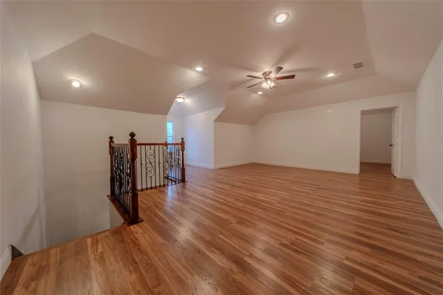 a view of a room with wooden floor and ceiling fan