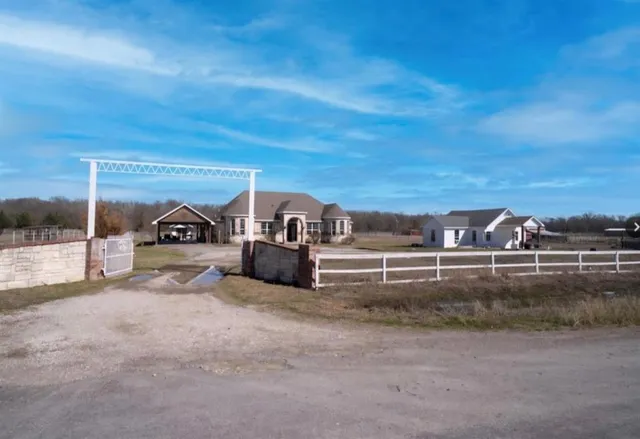 a view of house with yard and sitting area