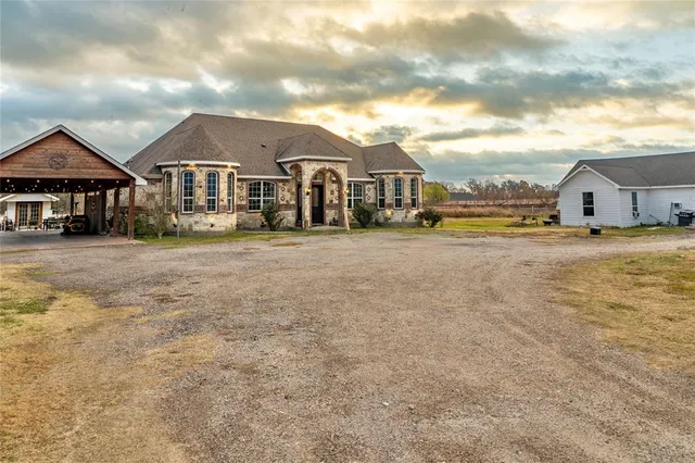 a view of a big house with a big yard and large trees
