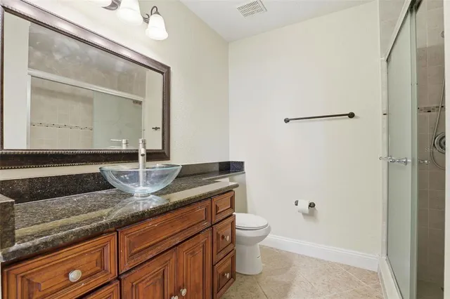 a bathroom with a granite countertop sink a toilet and a mirror