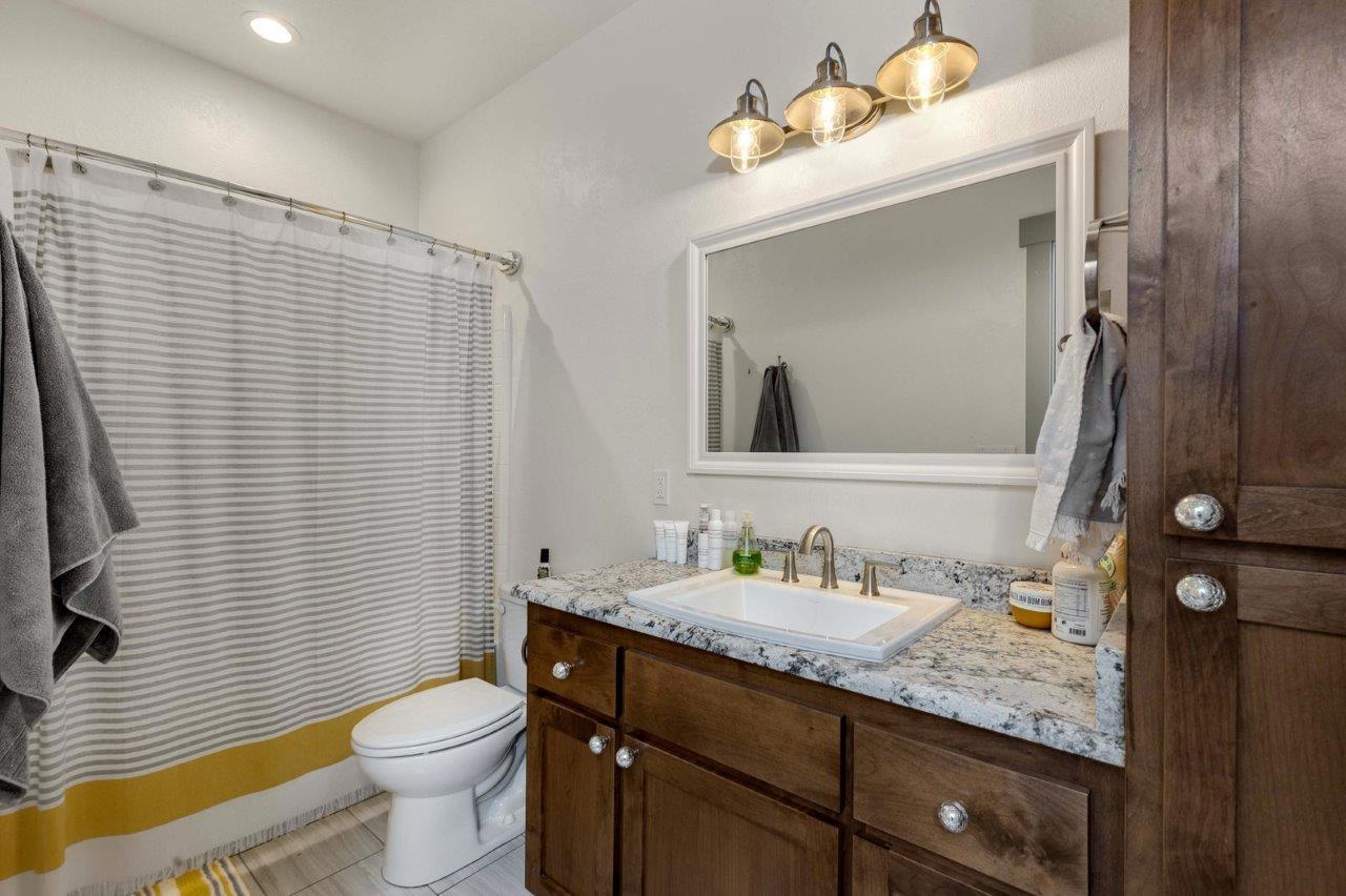 4684 Brownsboro-Meridian Road Eagle Point, OR 97524 - Photo 21 of 33 a bathroom with a granite countertop sink vanity mirror and toilet