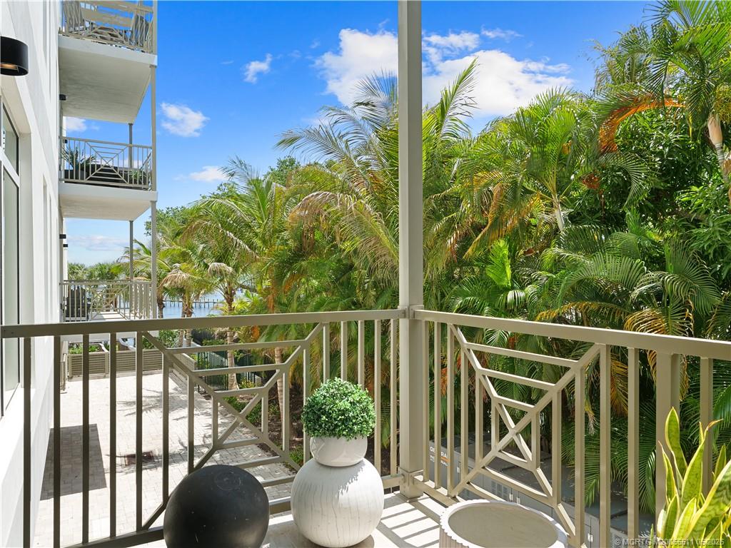 41 Southwest Seminole Street, Unit 208 Stuart, FL 34994 - Photo 18 of 46 a view of a balcony with table and chairs and wooden fence