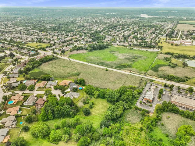 an aerial view of residential houses with outdoor space and trees