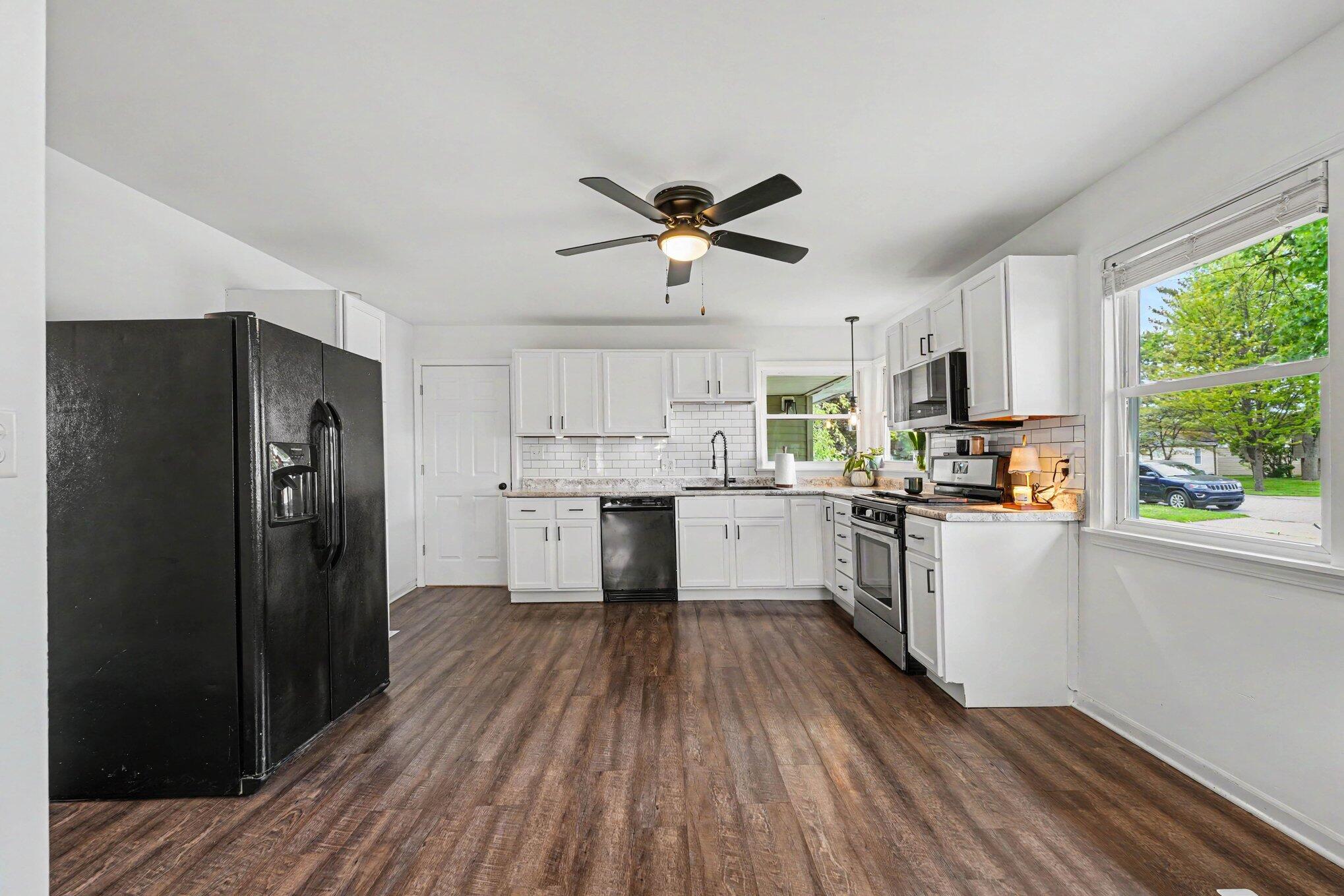 835 North Indiana Street Griffith, IN 46319 - Photo 5 of 19 a kitchen with a refrigerator a sink and dishwasher a refrigerator with wooden floor