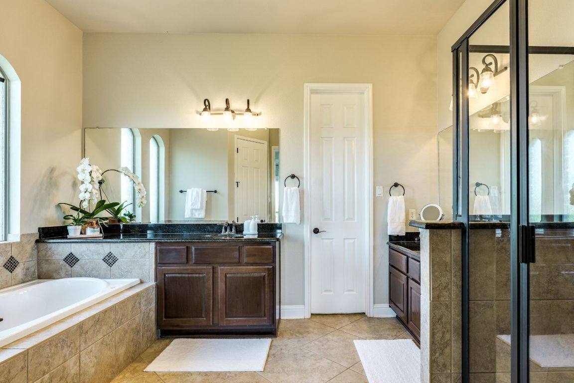 306 Tavish Trail Austin, TX 78738 - Photo 28 of 40 a spacious bathroom with a tub sink and mirror