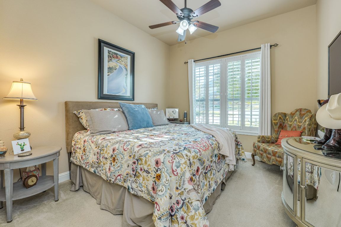 306 Tavish Trail Austin, TX 78738 - Photo 31 of 40 a bedroom with a bed and a chandelier
