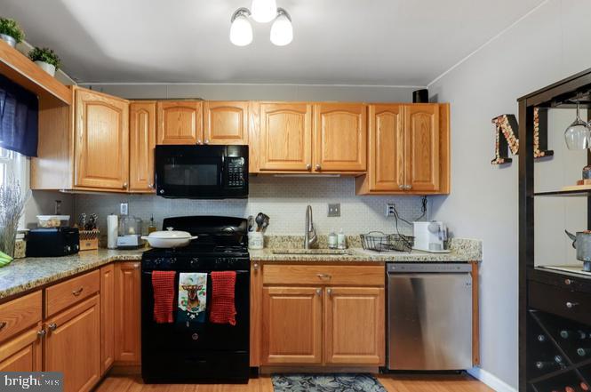 13705 Kerrydale Road Woodbridge, VA 22193 - Photo 13 of 32 a kitchen with stainless steel appliances granite countertop a stove a sink dishwasher and a microwave oven with cabinets