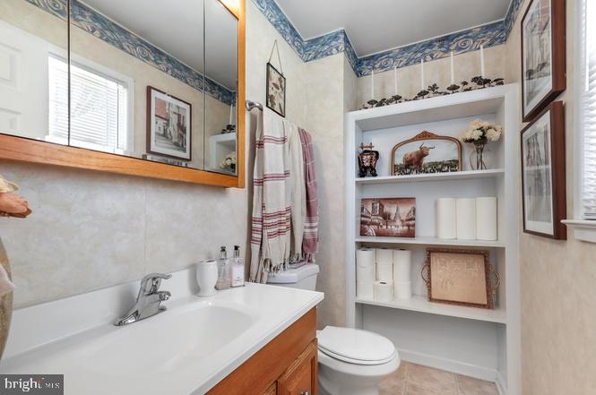 13705 Kerrydale Road Woodbridge, VA 22193 - Photo 16 of 32 a bathroom with a sink a toilet and a shower curtain