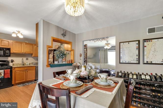 13705 Kerrydale Road Woodbridge, VA 22193 - Photo 10 of 32 a view of a dining room with furniture a chandelier and wooden floor