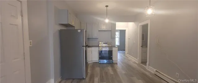 a view of a kitchen with a refrigerator and a stove top oven