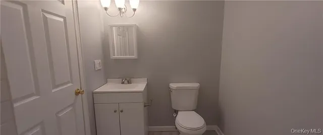 a bathroom with a toilet sink vanity and mirror