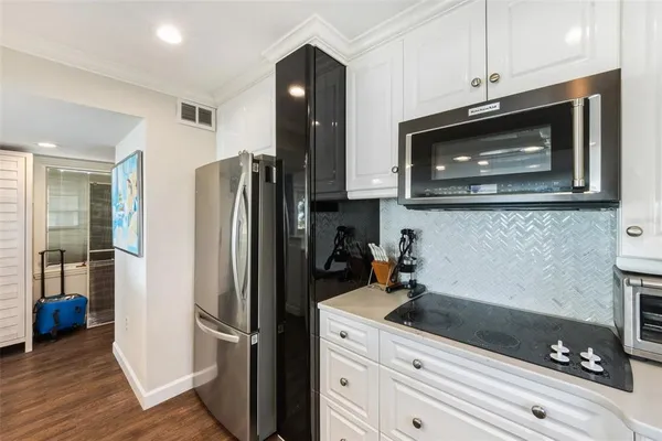 a kitchen with appliances a refrigerator and cabinets
