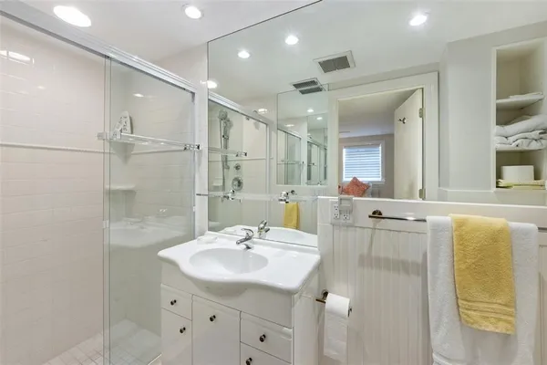a bathroom with a double vanity sink mirror and shower