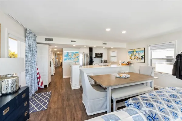 a living room with stainless steel appliances furniture and a table