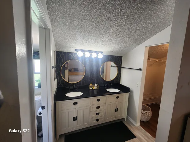 a bathroom with double vanity and a mirror