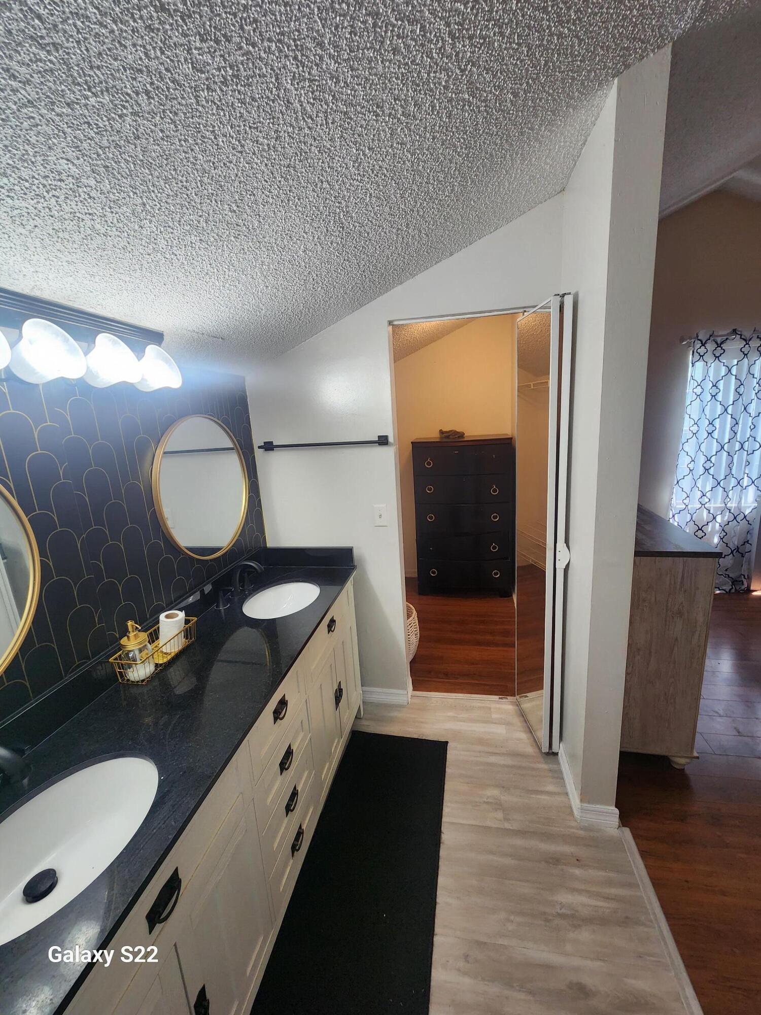 5884 Dewberry Way West Palm Beach, FL 33415 - Photo 23 of 26 a en suite bathroom with a double vanity sink and a mirror