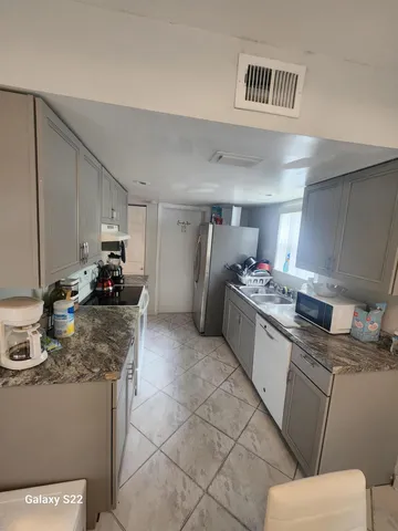 a kitchen with granite countertop a sink stove and cabinets