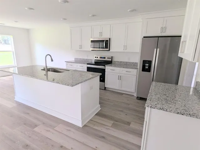 a kitchen with sink a microwave and refrigerator