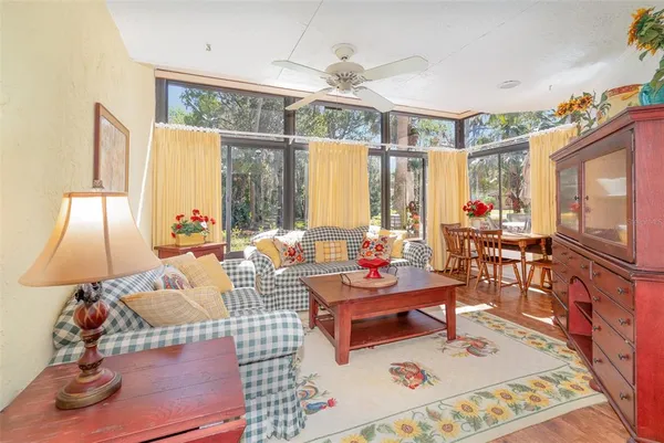 a living room with patio furniture and a chandelier