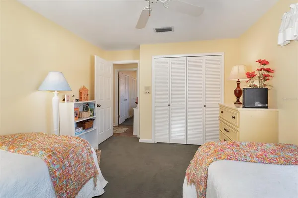 a bedroom with a bed and a flat tv screen on the dresser