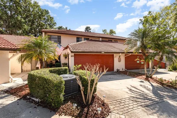 a view of a white house with a yard and potted plants