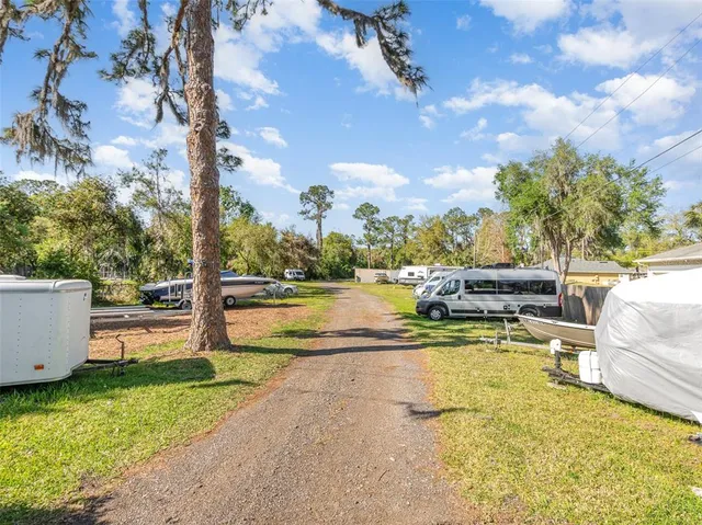 a view of a swimming pool with a patio and a yard