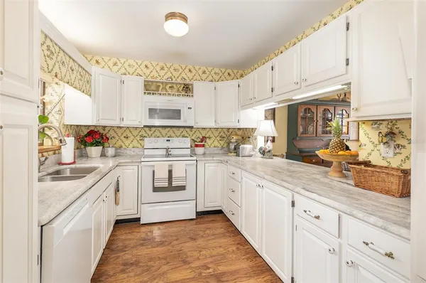 a kitchen with white cabinets and white appliances