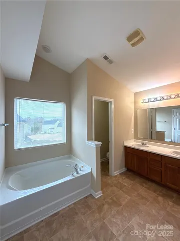 a view of spacious bathroom with bathtub and shower