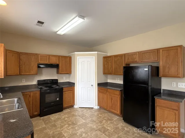 a kitchen with a refrigerator and a stove