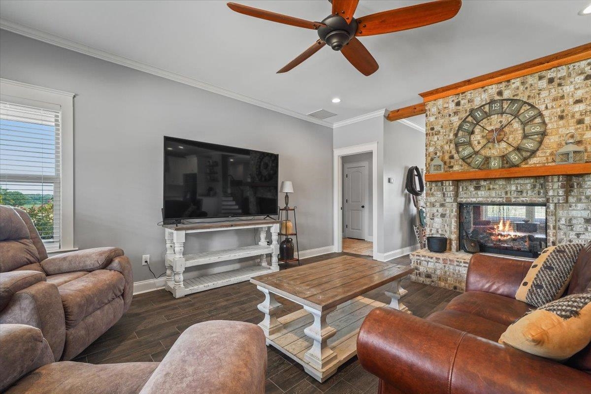 4374 Gainsville Road Mason, TN 38049 - Photo 11 of 40 Living area with a brick fireplace, ornamental molding, wood finished floors, ceiling fan, and recessed lighting