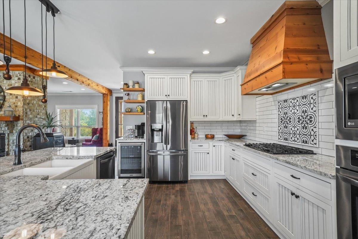4374 Gainsville Road Mason, TN 38049 - Photo 14 of 40 Kitchen featuring white cabinetry, light stone countertops, hanging light fixtures, appliances with stainless steel finishes, and decorative backsplash