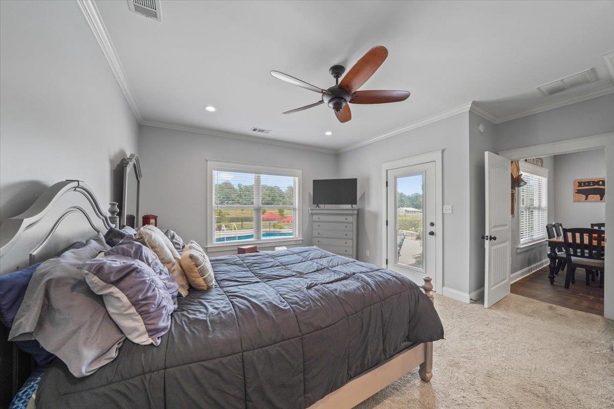 4374 Gainsville Road Mason, TN 38049 - Photo 17 of 40 Carpeted bedroom with crown molding, multiple windows, access to outside, a ceiling fan, and recessed lighting