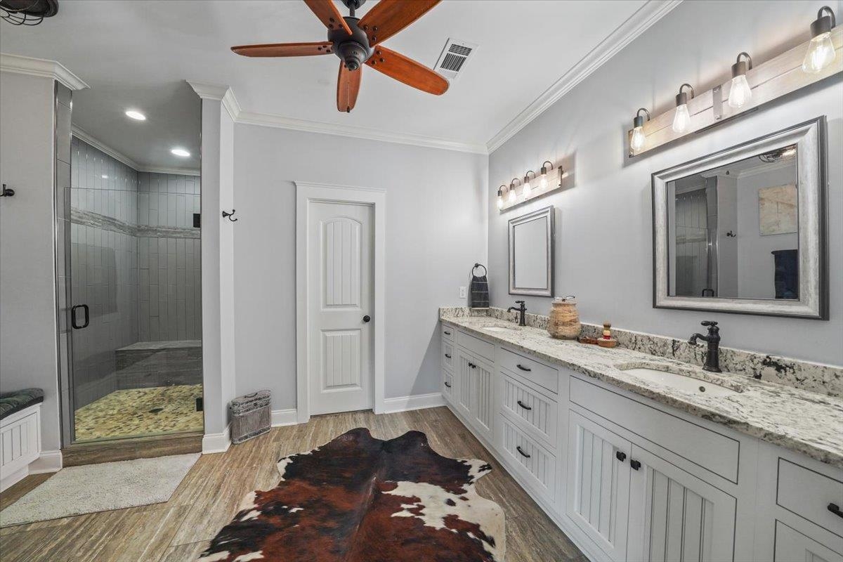 4374 Gainsville Road Mason, TN 38049 - Photo 18 of 40 Bathroom with light wood-type flooring, double vanity, a shower stall, crown molding, and a ceiling fan