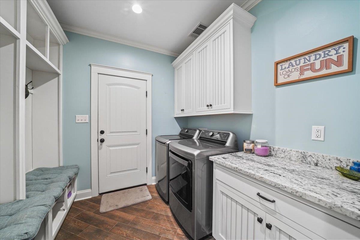 4374 Gainsville Road Mason, TN 38049 - Photo 20 of 40 Laundry room with ornamental molding, dark wood-type flooring, separate washer and dryer, and cabinet space