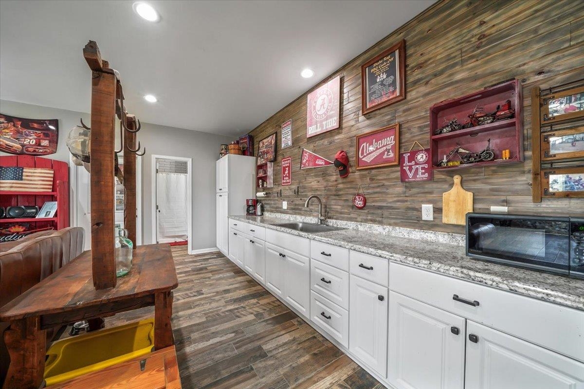 4374 Gainsville Road Mason, TN 38049 - Photo 29 of 40 Kitchen with white cabinetry, black microwave, dark wood-style flooring, open shelves, and light stone countertops