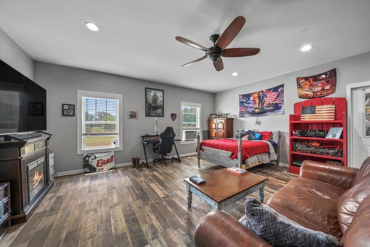 4374 Gainsville Road Mason, TN 38049 - Photo 30 of 40 Bedroom with an office area, dark wood finished floors, ceiling fan, a glass covered fireplace, and recessed lighting