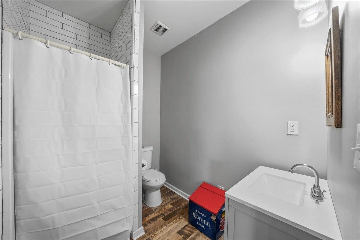 4374 Gainsville Road Mason, TN 38049 - Photo 31 of 40 Full bath with vanity, dark wood-style floors, and curtained shower