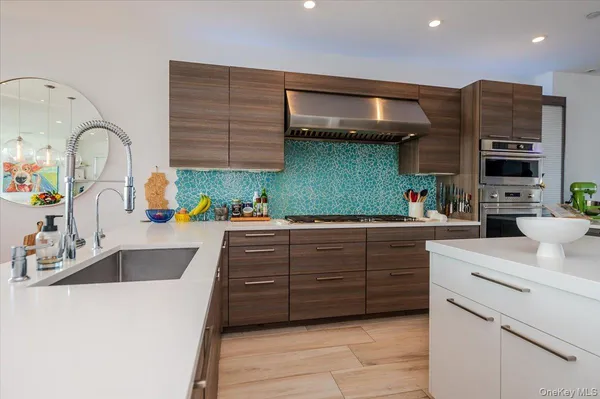 a kitchen with a sink and a stove with wooden floor