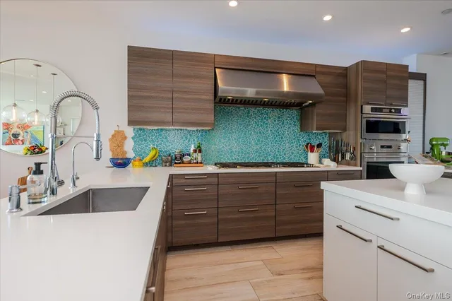a kitchen with a sink and a stove with wooden floor