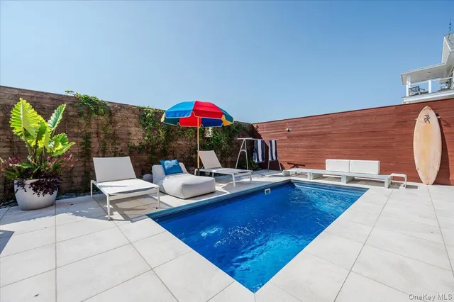 a view of a backyard with swimming pool and furniture