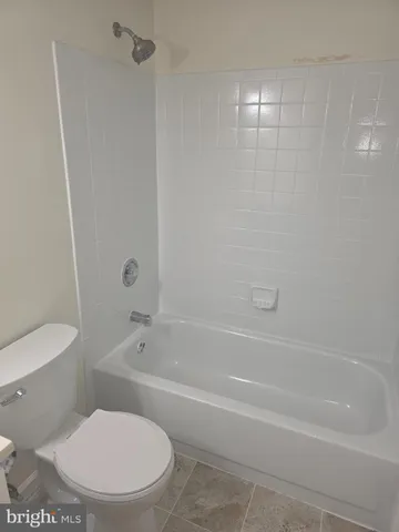 a white toilet and tub sitting next to a bathroom sink