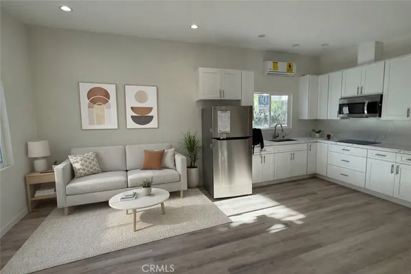 a living room with furniture a refrigerator and a sink