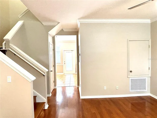 a view of a big room with wooden floor and windows