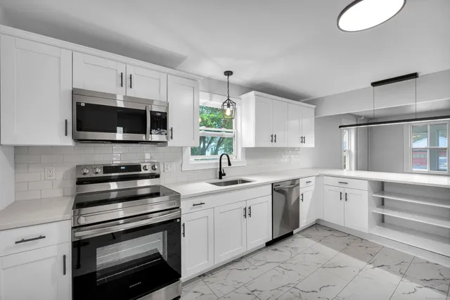 a kitchen with a sink stove and microwave