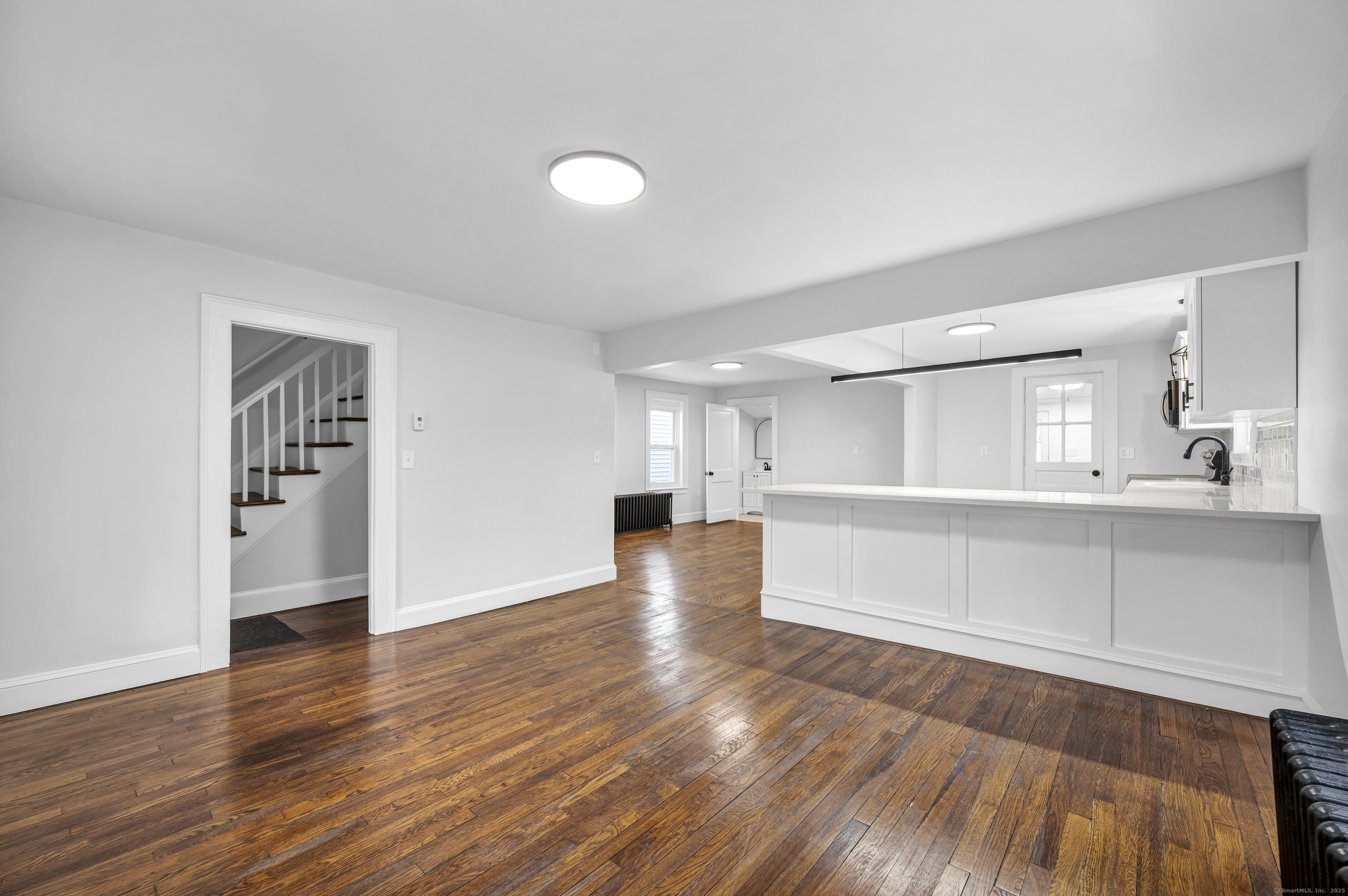291 Main Street Cromwell, CT 06416 - Photo 13 of 38 a view of empty room with wooden floor and kitchen
