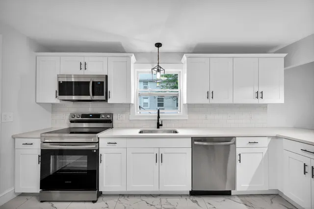 a kitchen with a sink stove and microwave