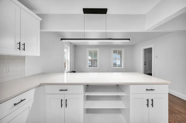 a kitchen with a sink cabinets and wooden floor