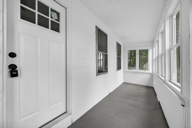an entryway with wooden floor and windows