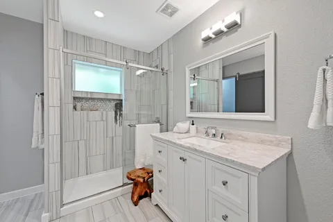 a bathroom with a sink vanity tub and shower
