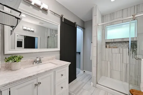 a bathroom with a granite countertop sink and a mirror